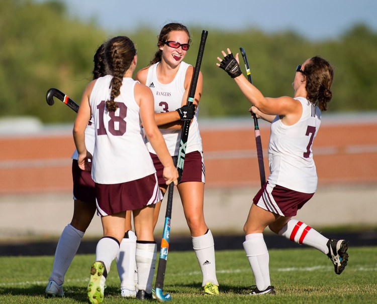 Greely players run up to hug sophomore Maddy Perfetti (3) after she scored the winning goal in overtime against Lake Region. Greely won 3-2. Brianna Soukup/Staff Photographer