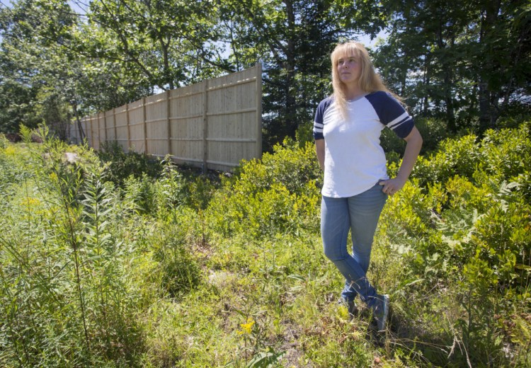 The attorney for Rebecca Abbott, above, who runs Kick Start Stables with her husband, says Paul Coulombe built an illegal "spite fence" along the edge of his golf course.