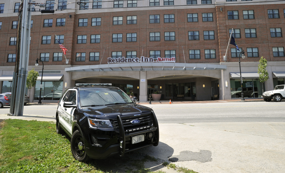 A police car sits outside the Residence Inn at 145 Fore St. in Portland where 28-year-old Espen Brungodt was arrested Wednesday in connection with threats to kill police officers made via email and Twitter. Brungodt, from Norway, had been staying at the hotel while vacationing with family in Maine.