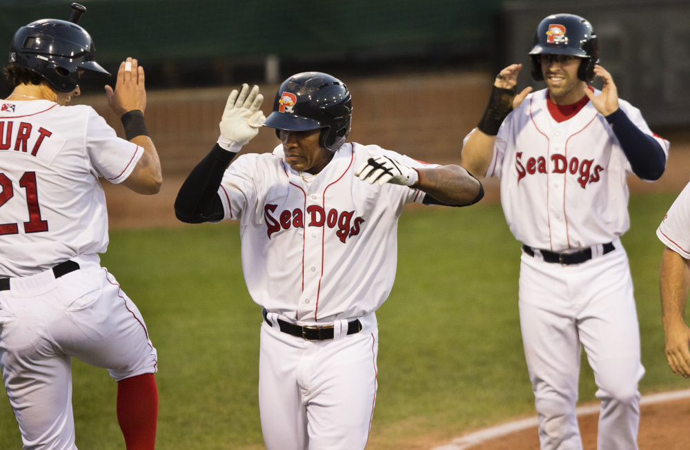 Portland Sea Dogs player Ryan Court celebrates Rainel Rosario's fourth-inning grand slam against Erie at Hadlock Field in Portland on Wednesday. Sea Dogs outfielder Cole Sturgeon, also knocked home on the play, smiles in the background at right. Portland held on for a 5-4 win.