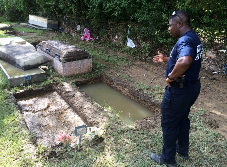 Willie Brooks III stands at the grave of his grandmother, whose body was lost in the floods, on Thursday in Plainview Cemetery in Denham Springs, La. 
Associated Press/Joshua Replogle