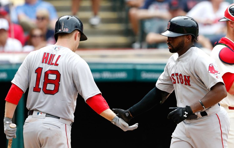 Boston’s Jackie Bradley (25) gets congratulations from Aaron Hill (18) after hitting a solo home run off Cleveland Indians starting pitcher Josh Tomlin during the sixth inning.