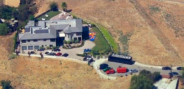 The home of entertainer Chris Brown with police vehicles outside, in the Tarzana area of Los Angeles Tuesday, Aug. 30, 32016. Authorities waited for a search warrant outside Brown's Los Angeles home after getting a woman's call for help, officials said. KABC-TV video image via AP