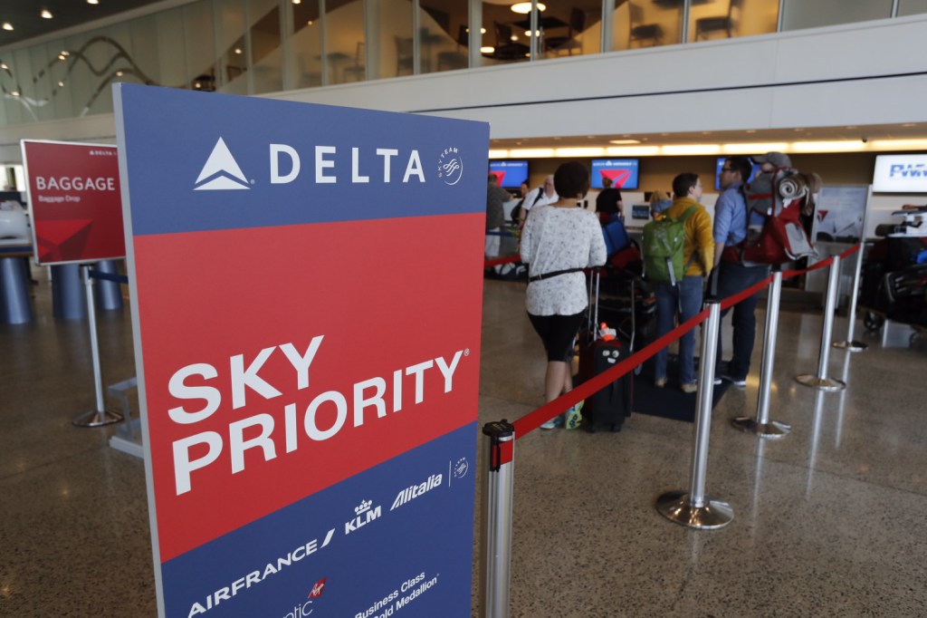 Passengers wait in line to check in for Delta flights Monday at the Portland International Jetport. Delta faced delays around the country because of a system problem in Atlanta.