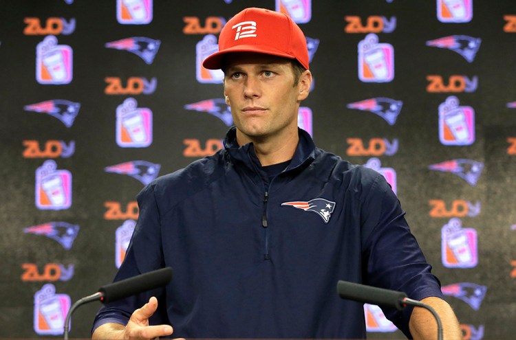 New England Patriots quarterback Tom Brady takes questions from  the news media before training camp practice Tuesday in Foxborough, Mass. He says he's available and ready to play a scheduled preseason game Friday at Carolina. Steven Senne/Associated Press