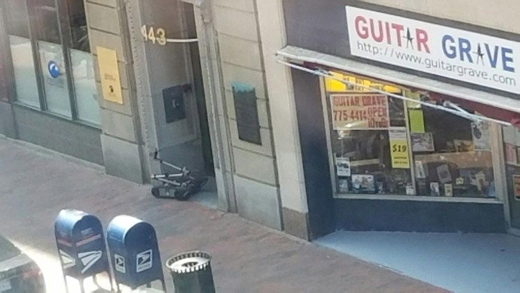 The Portland Police Department bomb squad deployed a robot, seen in the doorway of 443 Congress St., to investigate a suspicious package Tuesday.