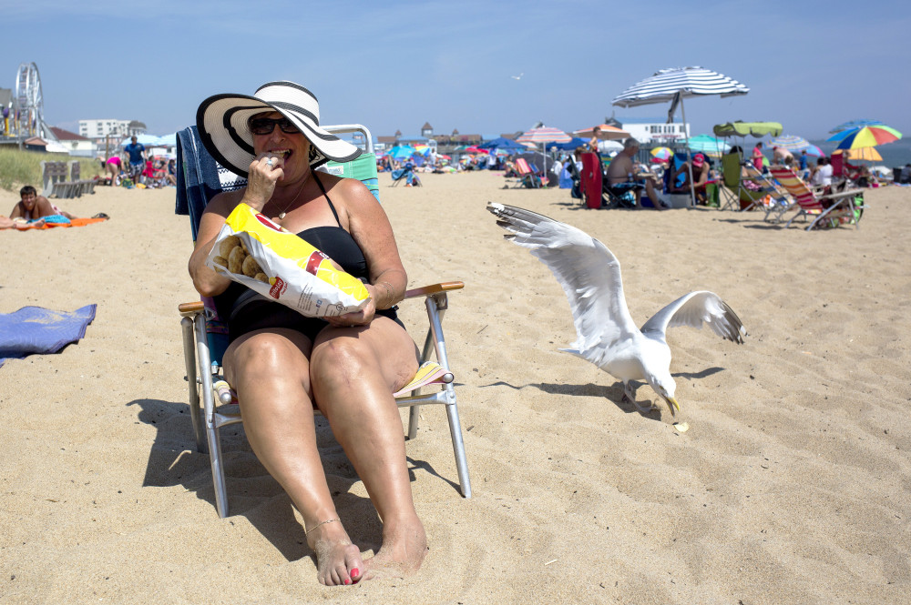 Susan Rancourt, a visitor from Saint-Georges, Quebec, who says she has been summering in Maine for years, soaks up some sun at Old Orchard Beach. (Briana Soukup/Staff Photographer)
