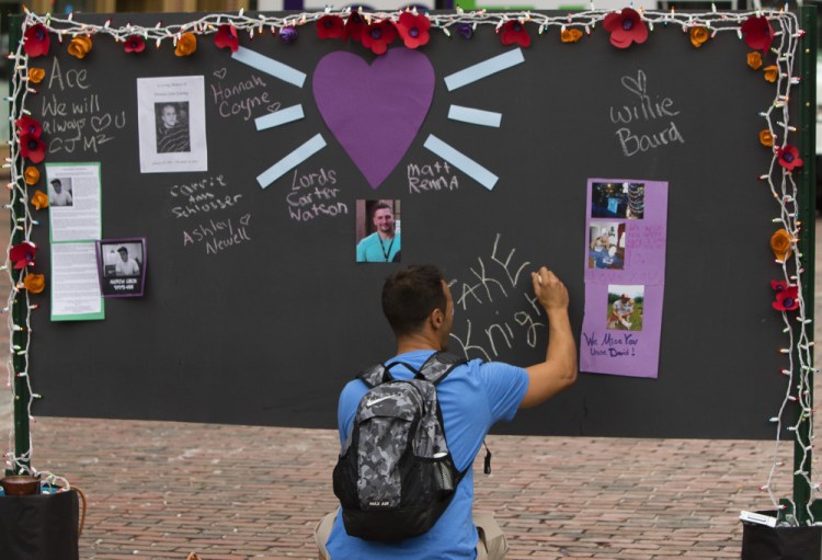 Will Clark of Portland writes the name of a friend he lost 15 years ago to a drug overdose on a memory board in Monument Square.
Carl D. Walsh/Staff Photographer