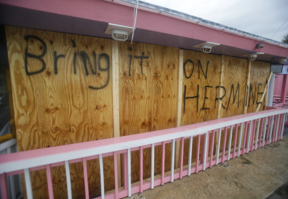 A hand-painted sign on a boarded up bar in Cedar Key, Fla., shows residents' defiance as Hurricane Hermine nears the Florida coast Thursday.