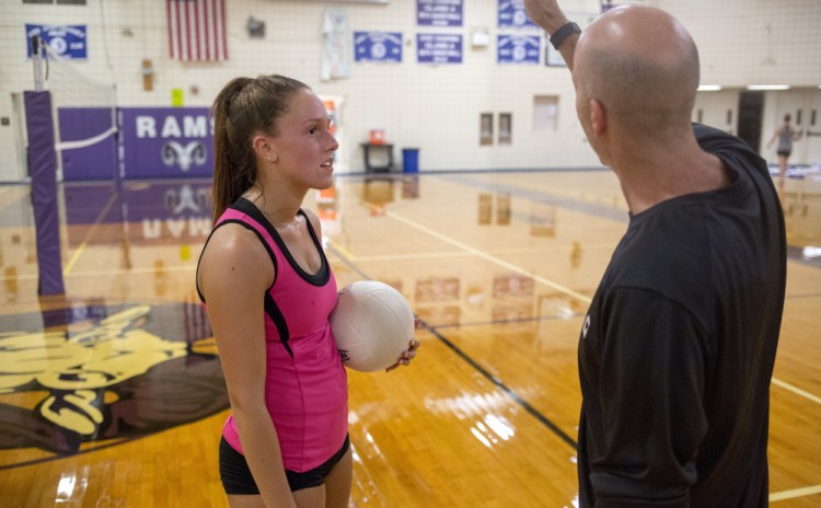 Coach Larry Nichols works with senior Kaylee Helmick during volleyball practice at Deering High. Deering went 7-7 in its first varsity season a year ago and has the potential to become of the premier programs in the state.