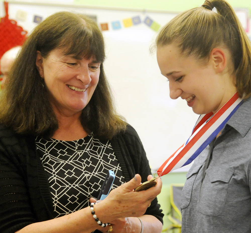 Monmouth Academy English teacher Christine Arsenault examines on Thursday a medal presented to student Maddie Amero for making a film with classmates that won best presentation from Maine at the National History Day Competition in Washington, D.C.