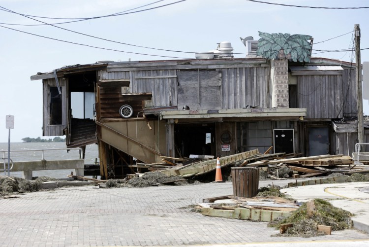 Debris lies near a waterfront building damaged by Hurricane Hermine on Friday in Cedar Key, Fla. Hermine was downgraded to a tropical storm after it made landfall, but was expected to strengthen against once it hit the Atlantic Ocean.