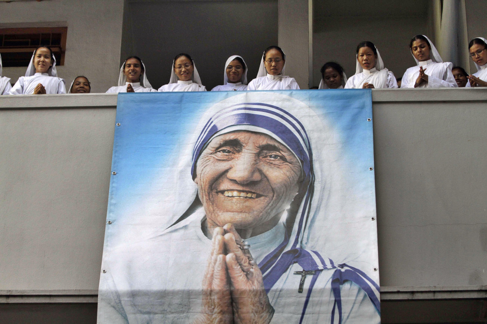 Nuns of Missionaries of Charity sing a hymn as a portrait of Mother Teresa hangs from a balcony during a congregation to mark her death anniversary in Kolkata, India, on Sept. 5, 2011. 