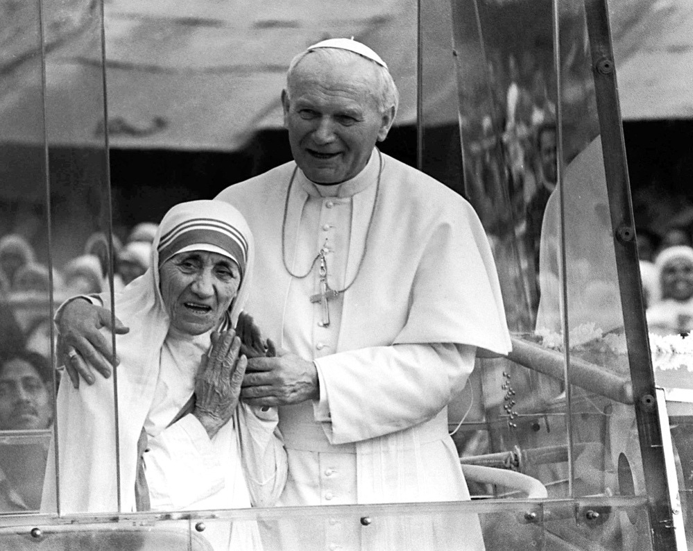 Pope John Paul II holds his arm around Mother Teresa in February 1986 as they ride in the popemobile outside the Home of the Dying in Calcutta, India. When Pope Francis canonizes Mother Teresa on Sunday, he'll be honoring a nun who won admirers around the world and a Nobel Peace Prize for her joy-filled dedication to the "poorest of the poor."
