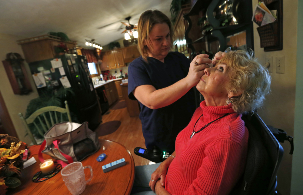 Jessica Haynes, left, a certified nursing assistant, applies eyedrops to Sandy Wright, who has an autoimmune disorder that damages her optic nerve and spinal cord, in Peoria, Ill., in 2013. Though mills and factories created the blue-collar middle class that we celebrate on Labor Day, the jobs that employ the most people today are in service sectors like health care.