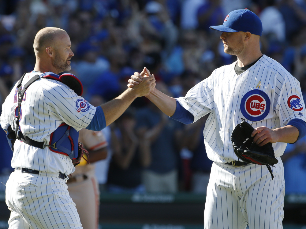 Chicago's Jon Lester, right, celebrates with catcher David Ross after a 2-1 win Friday over San Francisco at Wrigley Field.