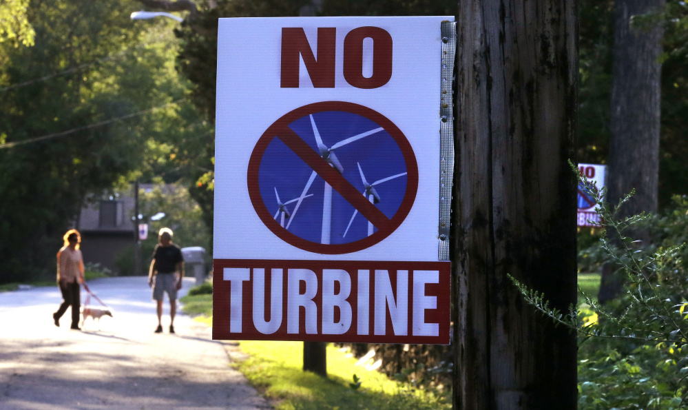 A sign against a proposed wind turbine hangs from a neighborhood telephone pole in North Smithfield, R.I. Even as Rhode Island makes history as the first state with an offshore wind farm, its people are not excited about wind turbines sprouting up on land near where they live.
