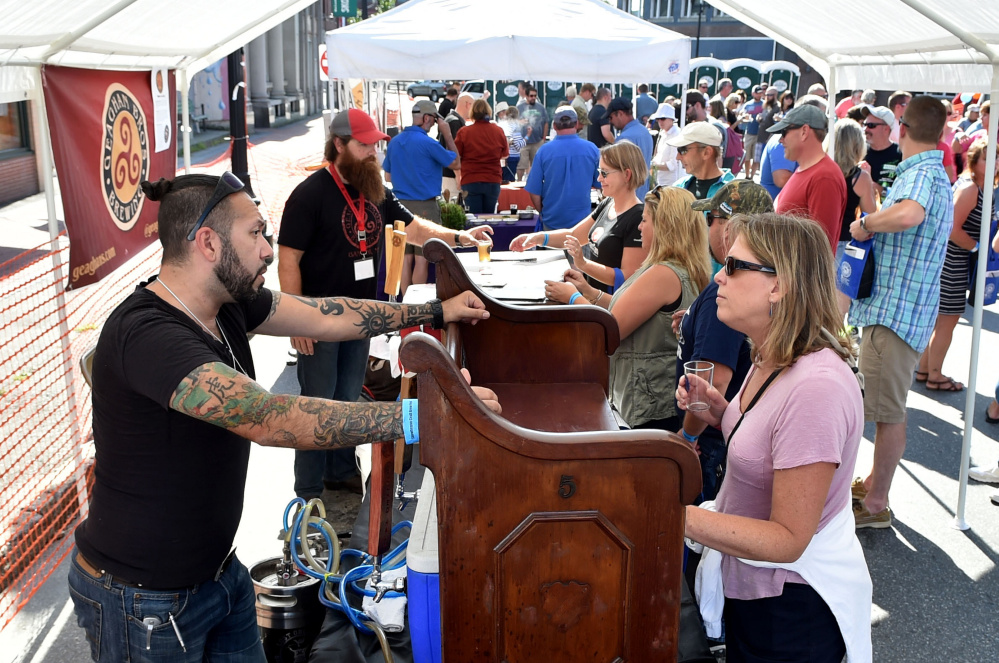 Donna Archambault talks with David Bouchard, head brewer and owner of Crooked Halo Cider, on Saturday at the first Skowhegan Craft Brew Festival.