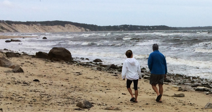 A couple walk along Sagamore Beach in Bourne, Mass., on Monday as Hermine whips up heavy surf on Cape Cod Bay and churns hundreds of miles out in the Atlantic Ocean.
