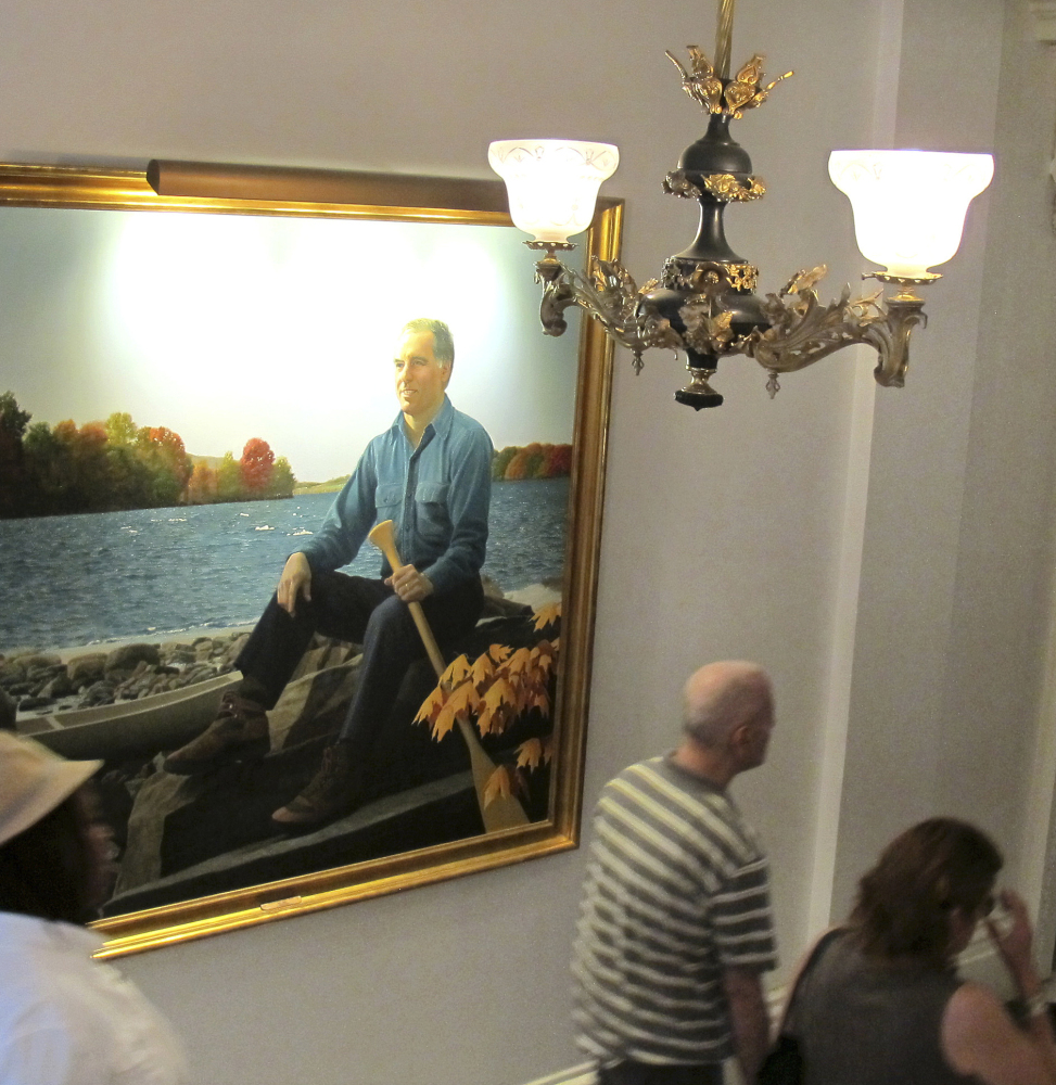 People walk past the official portrait of former Vermont Gov. Howard Dean. Vermont Statehouse curator David Schutz says the state has images of all but five of its 81 governors.