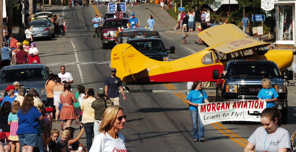 A head-turning airplane on a float from Morgan Aviation makes its way down Main Street .