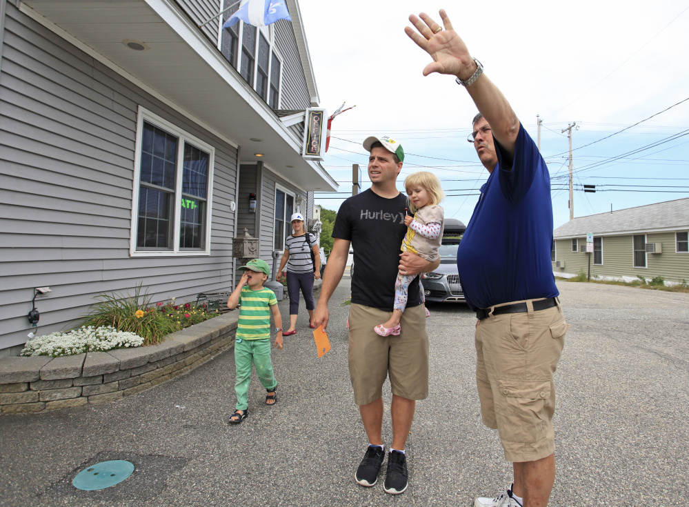 Mike Bouffard, owner of the Normandie Inn in Old Orchard Beach, points out a room location while helping the Adam family from Quebec check in Monday morning. The family had been motel-hopping since Wednesday as prices and availability fluctuated over the holiday weekend. Labor Day weekend capped an extra busy season for Bouffard. He said, "The Canadians took it on the chin with the exchange rate," but good weather kept motels full.