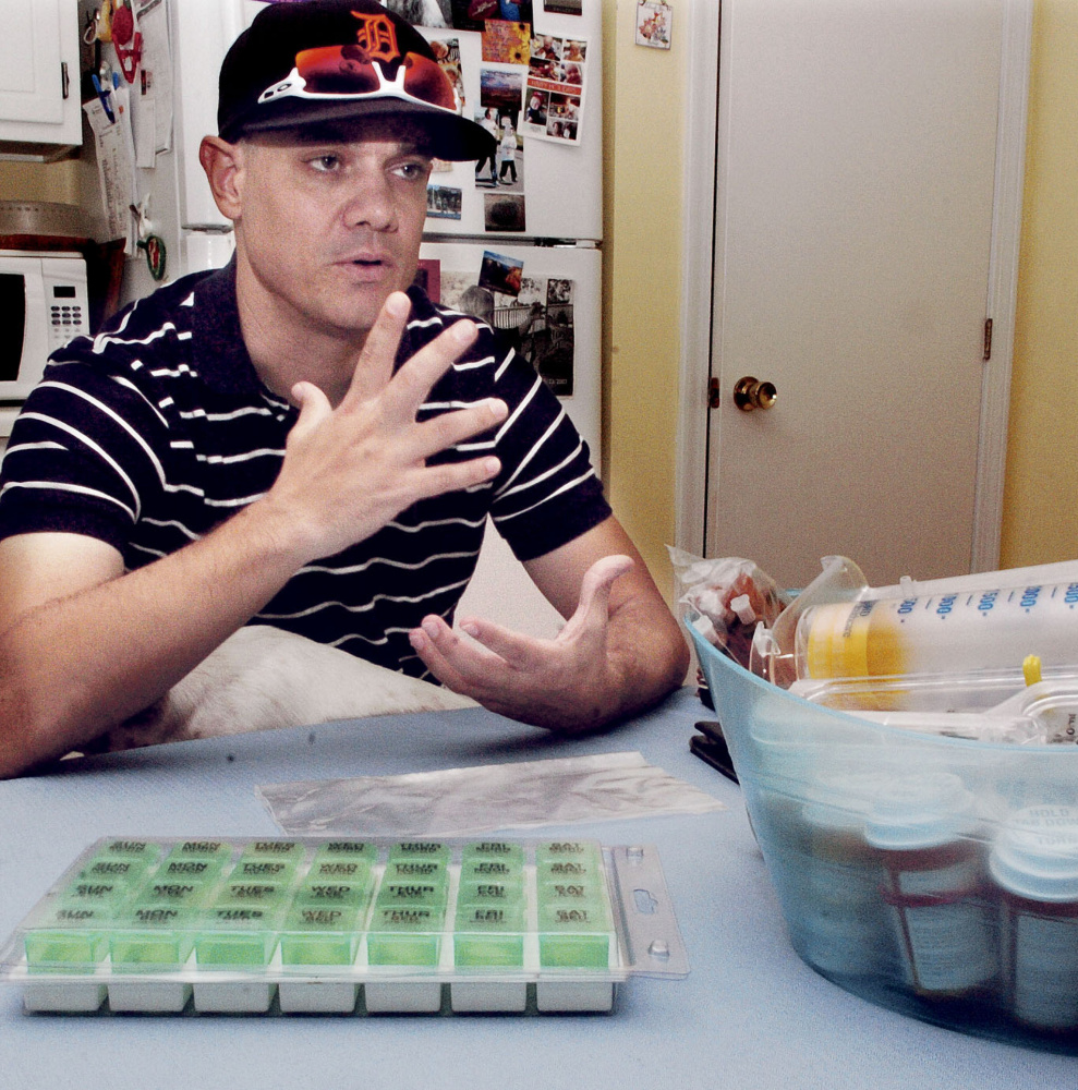 Michael Bowles sits at his Manchester apartment with various medicines he must take following a successful kidney transplant. Bowles was facing end-stage kidney failure before a transplant.