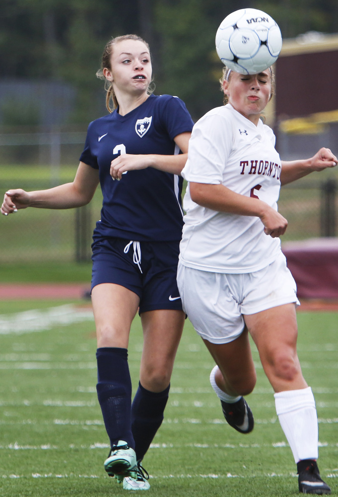 Alyanna Beaudoin of Thornton Academy, right, heads the ball away from Khloe Langella of Westbrook during the second half. Thornton improved to 2-0 and dropped the Blue Blazes to 0-2.