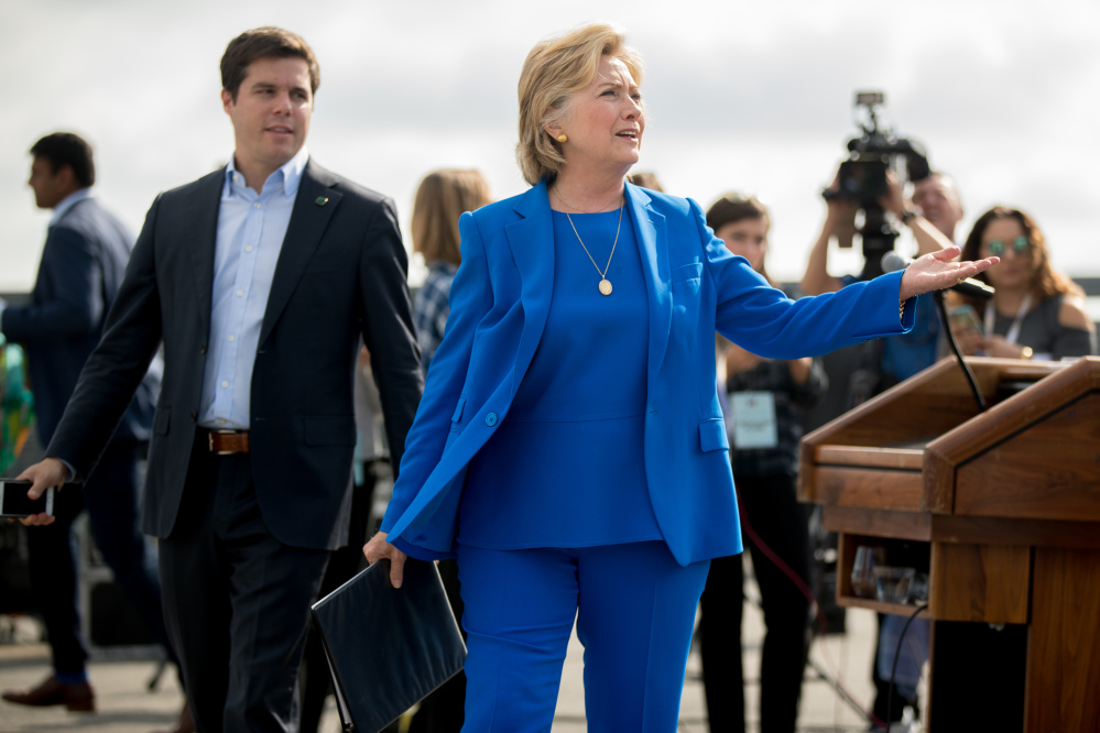 Democratic presidential nominee Hillary Clinton, accompanied by traveling press secretary Nick Merrill, left, reacts to a reporter's question as she finishes speaking to members of the media before boarding her campaign plane at Westchester County Airport in White Plains, N.Y., on Thursday.