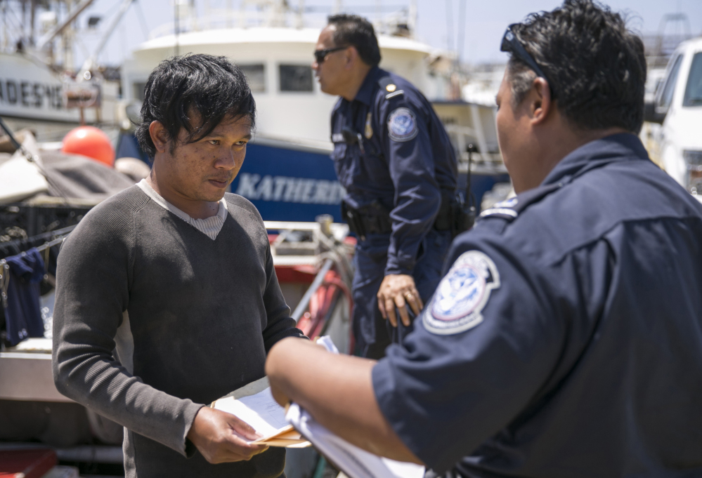 In Hawaii, U.S. Customs and Border Protection officer Ericson Padilla checks the documents of an Indonesian fisherman who might spend weeks in cramped, dangerous quarters at sea while earning wages that won't go far outside the Third World.
Marco Garcia/Associated Press