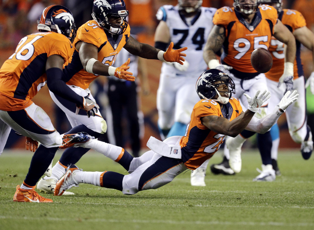 Denver Broncos cornerback Chris Harris intercepts the ball against the Carolina Panthers to set up a touchdown run during the second half Thursday in Denver.