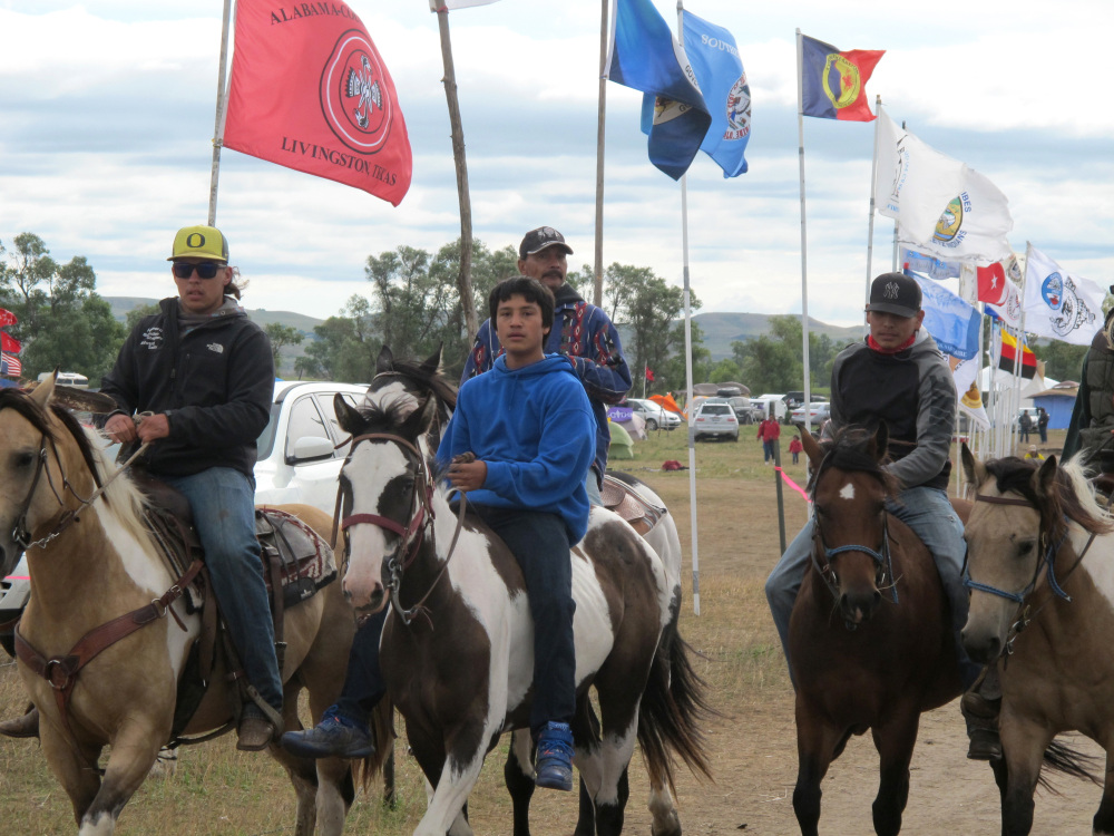 Horseback riders make their way through an encampment near North Dakota's Standing Rock Sioux reservation on Friday. The Standing Rock Sioux tribe's attempt to halt construction of an oil pipeline near its North Dakota reservation failed in federal court Friday, but three government agencies asked the pipeline company to "voluntarily pause" work on a segment that tribal officials say holds sacred artifacts.