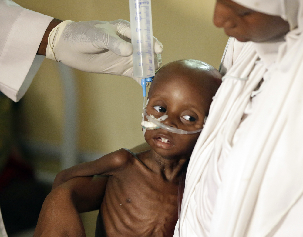A doctor feeds a malnourished child at a feeding center run by Doctors Without Borders in Maiduguri, Nigeria. A quarter of the children lucky enough to make it to the emergency feeding center are dying.