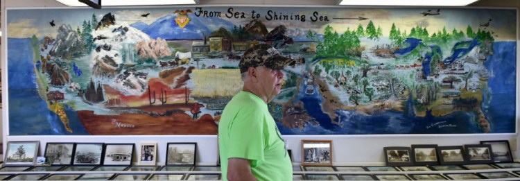 Buddy Frost, president of the Clinton Historical Society, stands in front of a mural painted by Viva Chamberlain in 1976 that's on display at the Clinton Lions Agricultural Fair in Clinton.