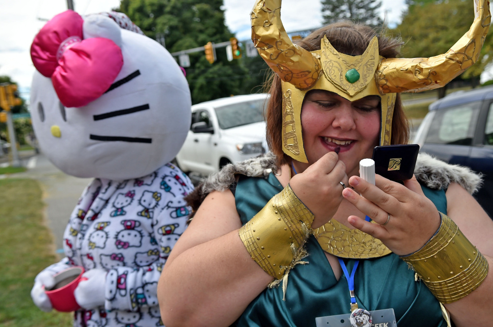 Emily Fournier, right, applies makeup to her fictional sci-fi character Loki Lady costume Saturday at the Waterville Public Library for the Cirque du Geek convention's parade.