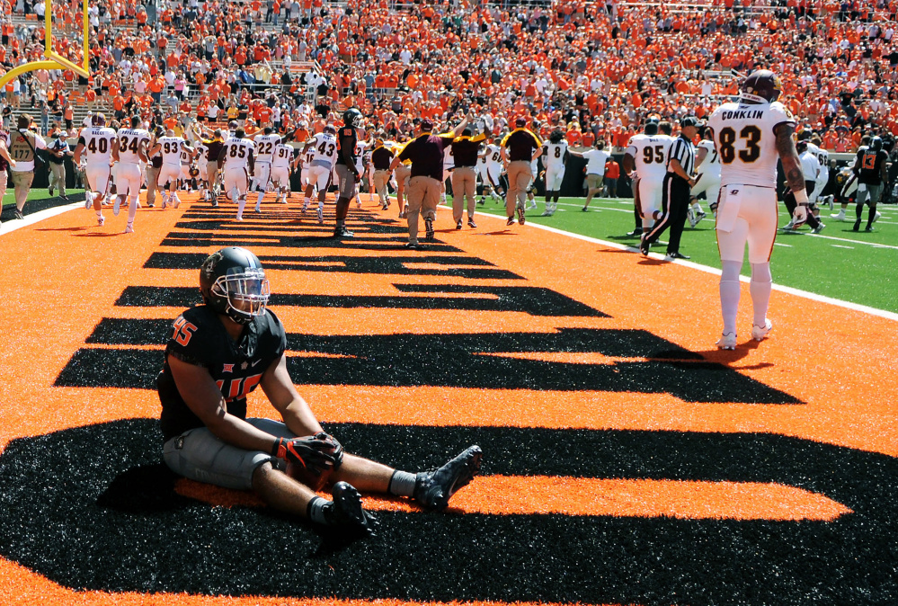 Oklahoma State linebacker Chad Whitener sits alone in the end zone while Central Michigan celebrates a last-second touchdown by receiver Corey Willis that gave the Chippewas a 30-27 win Saturday in Stillwater, Okla.