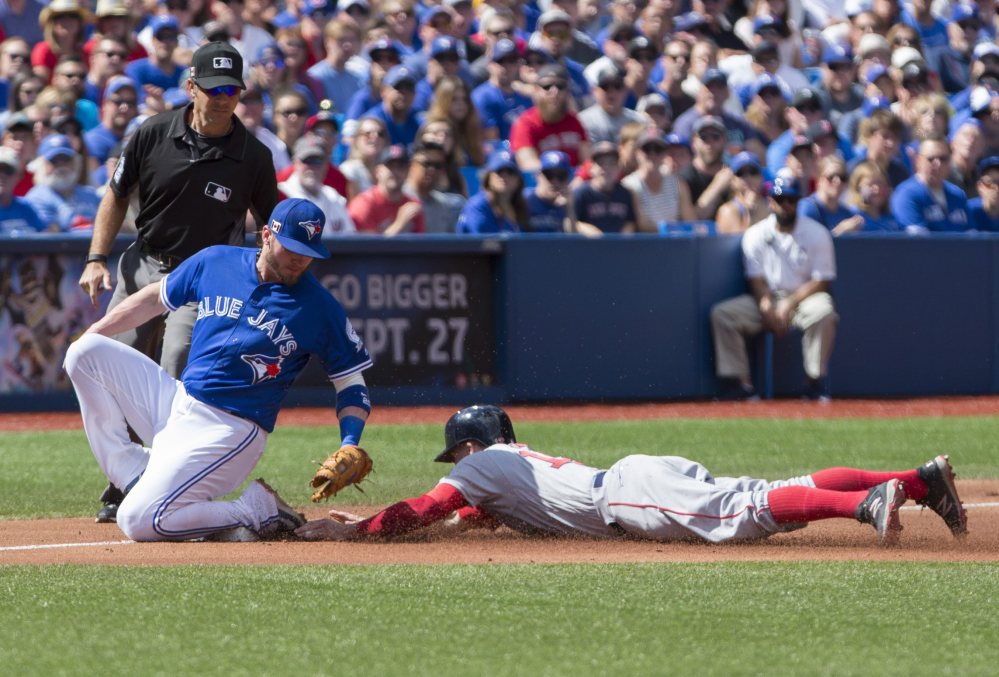Blue Jays third baseman Josh Donaldson tries to tag Red Sox left fielder Brock Holt as Holt slides safely into third for a stolen base during Boston's 11-8 win Sunday in Toronto.