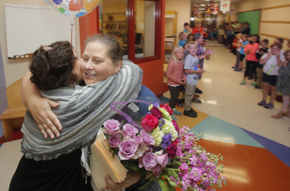 Stevens gets a hug from Principal Bonnie Hicks while receiving a schoolwide welcome home on Monday morning.