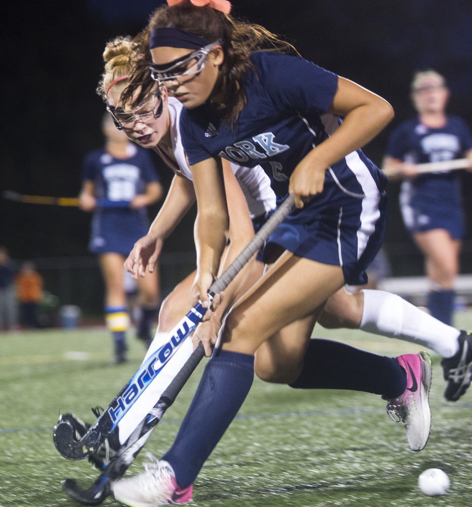 Yarmouth senior Liza Lunt, left, battles York freshman Cassie Reinertson for the ball Monday in Yarmouth. York scored twice in the second half to win 3-1. It was the 44th straight win for the Wildcats.
Brianna Soukup/Staff Photographer