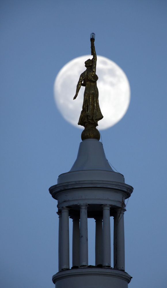 Associated Press/Robert F. Bukaty
Somethging from story , pls The nearly-full moon rises behind the draped female figure of Wisdom on top of the Maine state house, Friday, Jan. 9, 2009, in Augusta, Maine. Earlier in the day at the state house Gov. John Baldacci unveiled  his two-year state budget that proposes deep cuts in spending that include the elimination 219 state positions and a 2.4 percent cut in college funding. (AP Photo
