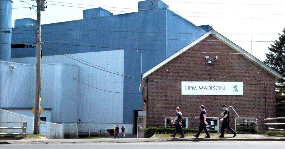 Millworkers carry tools into the Madison Paper Industries mill in Madison in May.