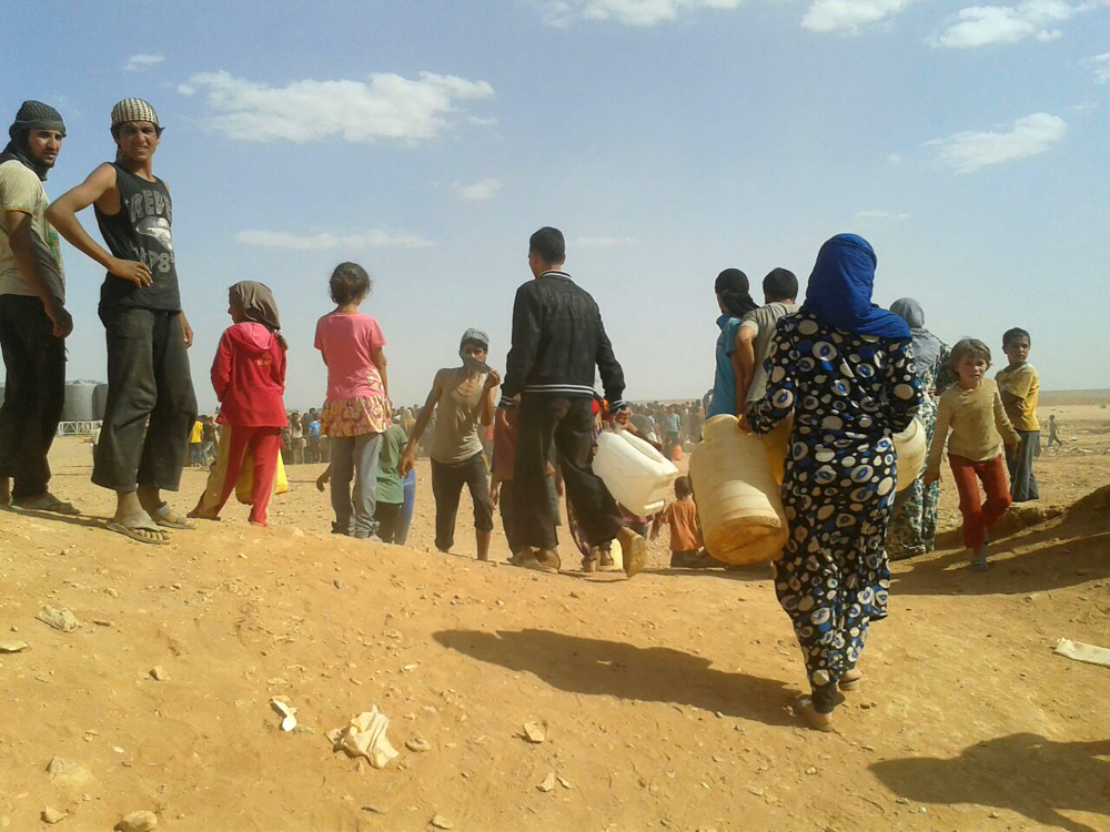 Syrian refugees gather for water at the Rukban refugee camp in Jordan's northeast border with Syria in June. Of the millions of exiles from the Syrian war, only about 10,000 have reached U.S. shores.