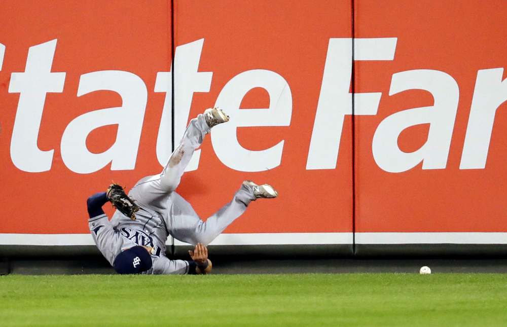 Rays center fielder Kevin Kiermaier collides with the outfield wall as he is unable to field a two-run double by J.J. Hardy of the Orioles during the first inning of Thursday's game in Baltimore. Tampa Bay pulled out a 7-6 victory.