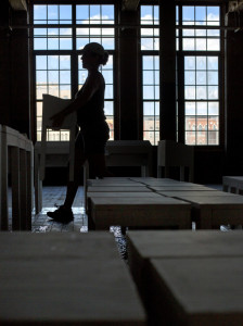 Assistant Cheyanne MacDougall at work on the installation with a view from the windows of the Bates Mill complex.