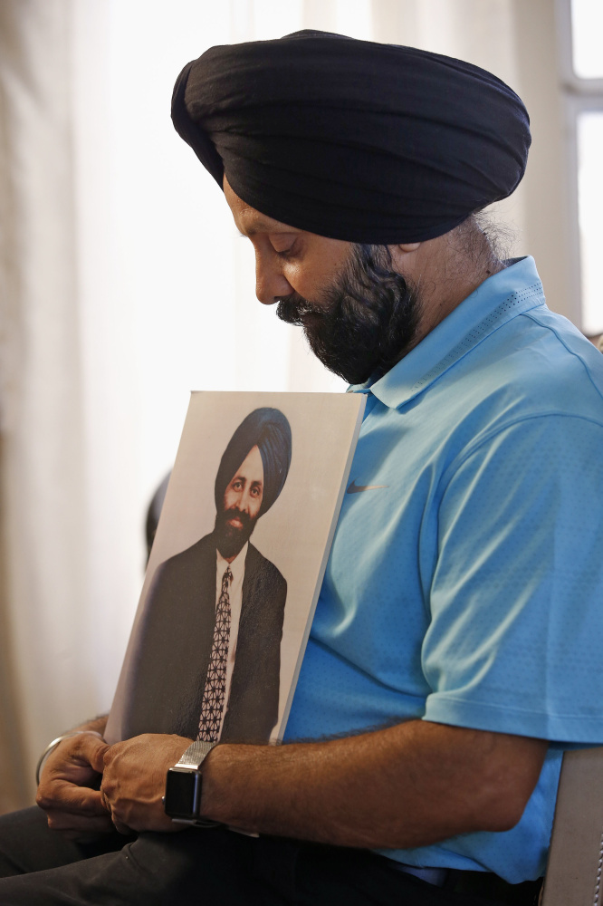 Rana Singh Sodhi, 49, holds a photograph of his brother, Balbir Singh Sodhi, in Gilbert, Ariz. Days after the Sept. 11, 2001 terrorist attacks, Balbir was shot dead outside his gas station in Mesa.