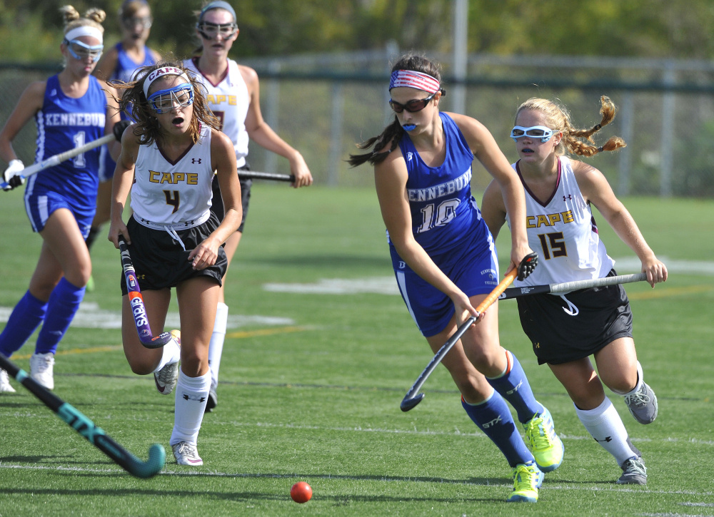 Grace Grenier, center, of Kennebunk is pursued by Julia Lennon and Erika Miller of Cape Elizabeth during their Western Maine Conference field hockey game Saturday. Kennebunk won, 8-1.