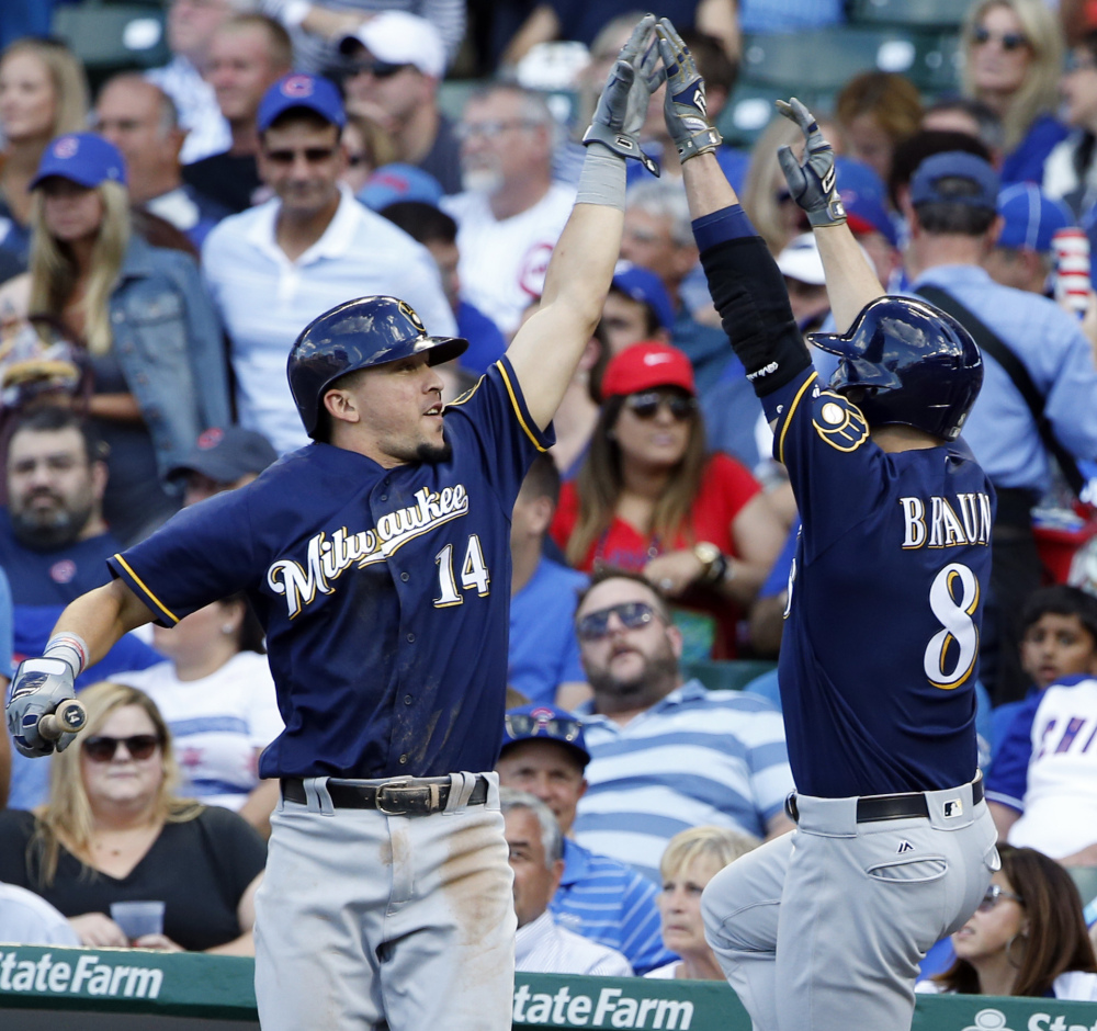 Milwaukee's Ryan Braun, right, celebrates with Hernan Perez after hitting a two-run homer in the sixth inning of the Brewers' 11-3 win against the Cubs in Chicago.