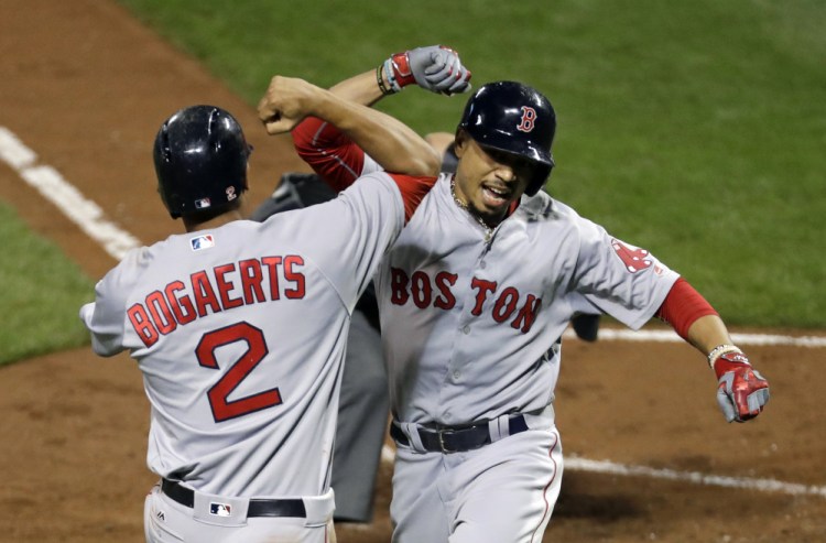 Mookie Betts celebrates with Xander Bogaerts after driving in Bogaerts on a home run on Sept. 19 in Baltimore, where the Red Sox swept the Orioles on their march to the top of the AL East.