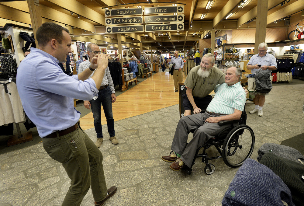 Evan Sisley, left, an aide to former President George H.W. Bush, seated, captures a memorable moment for Jerry Furr of Charlotte, N.C., at L.L. Bean in Freeport.