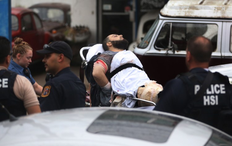 Ahmad Khan Rahami is taken into custody after a shootout with police Monday in Linden, N.J. He was charged Tuesday with planting explosives in New York and New Jersey.